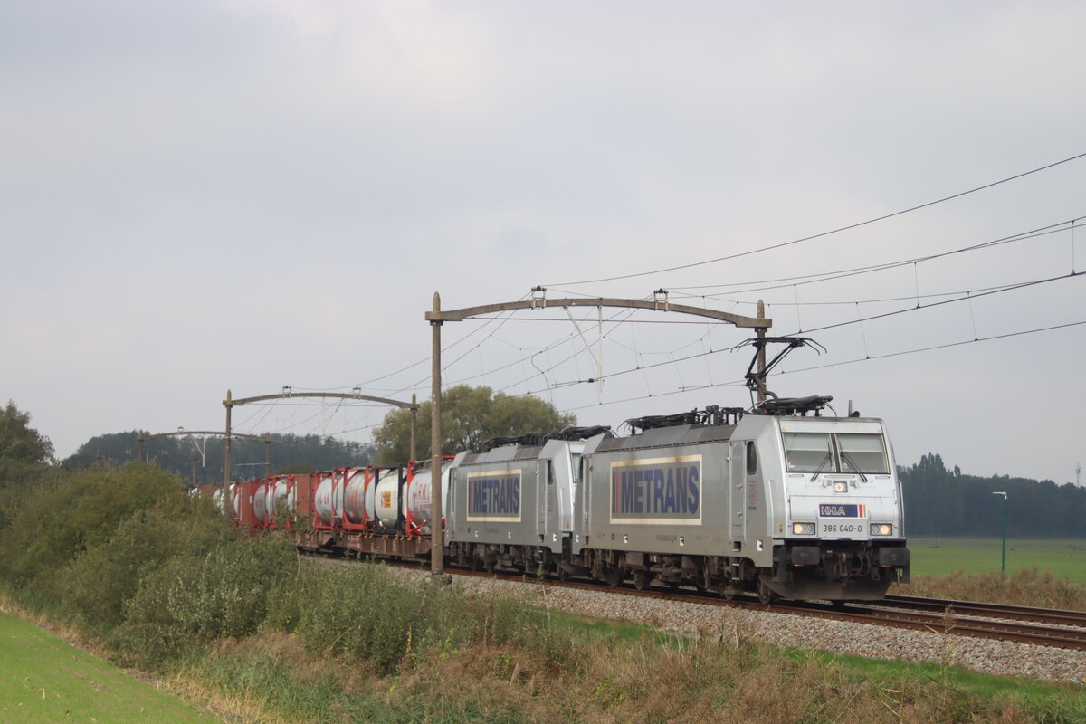 Hier durchfährt Metrans BR 386 040 mit BR 386 032 und einem Containerzug durch den Ort Hulten Richtung Tilburg am 27.9.2025